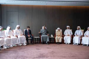 Theyab bin Mohamed bin Zayed is meeting with a group of Emirati students at Chinese universities. The image shows Sheikh Theyab seated in the center, speaking with a group of young men in traditional Emirati attire and one in a suit, all seated around him in a modern meeting room.