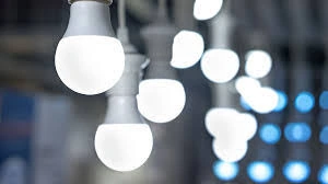 A collection of white LED light bulbs hanging from the ceiling, with some in sharp focus and others blurred in the background, creating a bokeh effect.