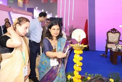 Ms. Roli Singh, Additional Secretary & Mission Director (NHM), Ministry of Health & Family Welfare, lights a traditional lamp at the India Public Health Week 2023 inaugural ceremony, accompanied by another official.