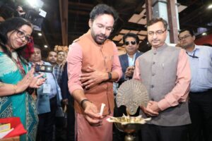 Union Minister of State for Information and Broadcasting, Dr. L. Murugan, lights a lamp alongside another dignitary at the India Pavilion during COP28 in Dubai, surrounded by other attendees.