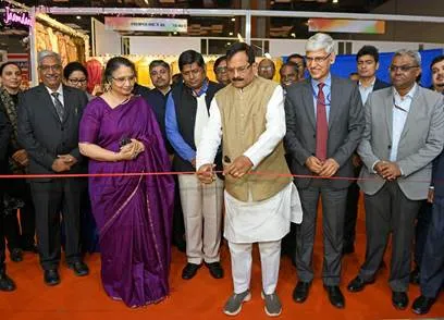 Shri Pralhad Joshi and Smt. Darshana Jardosh inaugurate the India International Mega Trade Fair 2024 by cutting a red ribbon, surrounded by other dignitaries and attendees at the exhibition venue.