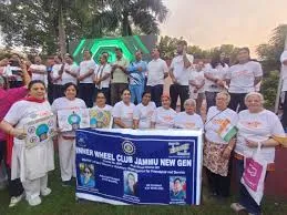 A large group of people, predominantly women, participate in a walkathon for "Ek Desh Ek Swasthya" (One Nation One Health) initiative, holding banners for Inner Wheel Club Jammu New Gen.