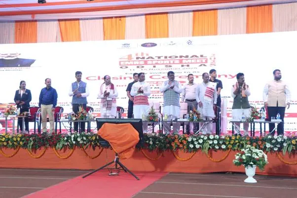 Dignitaries including Union Minister Shri Jual Oram and Odisha Chief Minister Shri Mohan Charan Majhi, stand on a stage with officials and international sprinter Ms. Dutee Chand, during the Closing Ceremony of the 4th National EMRS Sports Meet in Rourkela, Odisha. The event date is visible on the screen: 11-15 November 2025.