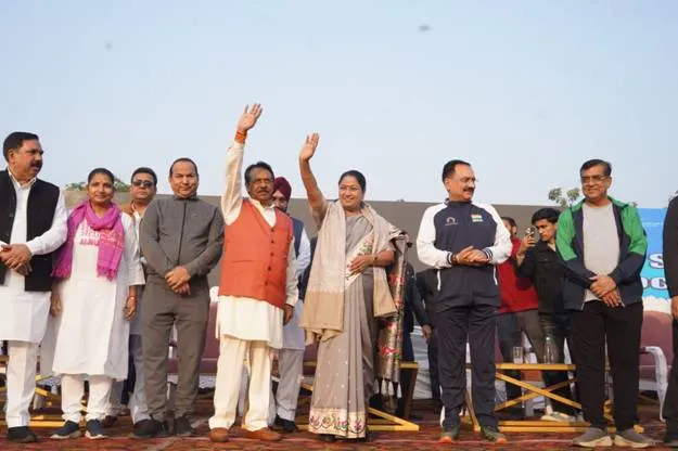 Minister of State Shri Harsh Malhotra (orange vest) and Delhi Chief Minister Mrs. Rekha Gupta (grey saree) wave, accompanied by other dignitaries, at the flagging off of the Namo Run on Road Safety at Yamuna Sports Complex, East Delhi.