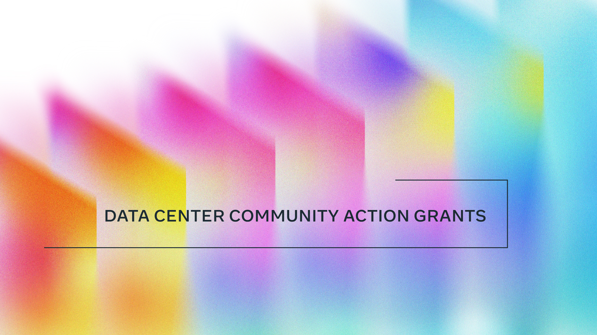 Abstract image featuring a gradient of blurred, colorful rectangular panels in shades of orange, pink, purple, yellow, and blue, with the white text "DATA CENTER COMMUNITY ACTION GRANTS" overlaid horizontally in the center. A thin black line underscores and brackets the text.