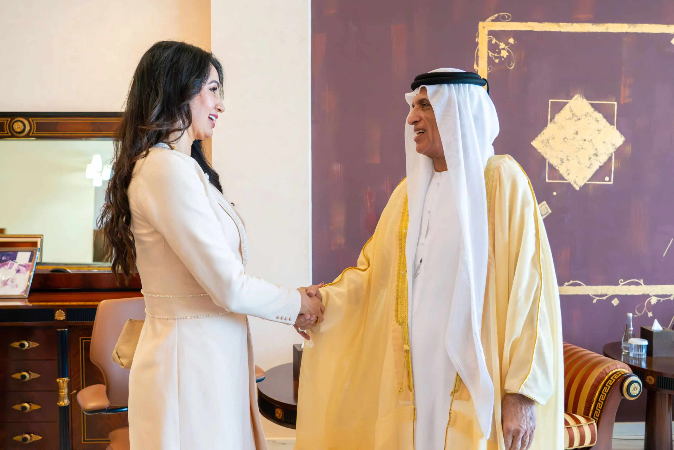 H.H. Sheikh Saud bin Saqr Al Qasimi, Ruler of Ras Al Khaimah, shakes hands with Carolin Konther López, Ambassador of Paraguay, during a meeting in a formal setting.