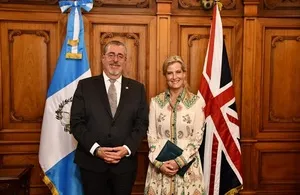 Sophie, Duchess of Edinburgh, stands next to the Guatemalan Minister of Foreign Affairs, Carlos Ramiro Martinez, in a formal room with the flags of Guatemala and the United Kingdom behind them.