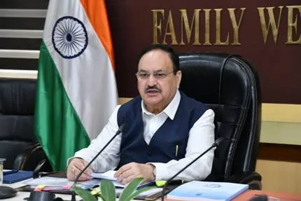 Union Health Minister Shri Jagat Prakash Nadda addresses a press conference, seated at a desk with an Indian flag behind him.