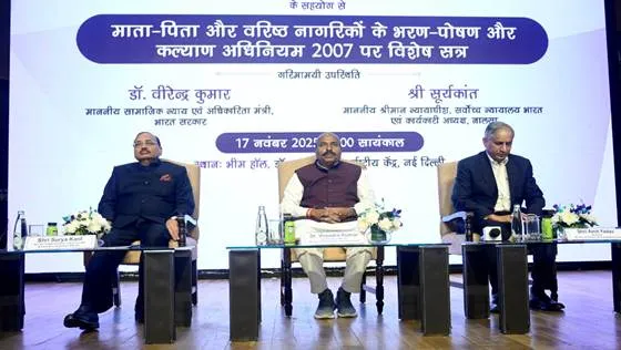 Dr. Virendra Kumar, Union Minister, Social Justice & Empowerment, and Mr. Justice Surya Kant, Judge, Supreme Court of India & Executive Chairman, NALSA, sit on stage at a special session in New Delhi. They are seated at a table with microphones, water bottles, and flowers, facing an audience. A large screen behind them displays the event title in Hindi and English, along with their names and titles.
