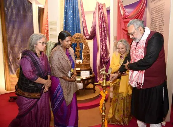 Union Minister Giriraj Singh lighting a ceremonial lamp during the inauguration of the Textile Pavilion at IITF 2025 in New Delhi, accompanied by Textile Secretary Neelam Shami Rao and officials amidst colorful handloom displays.