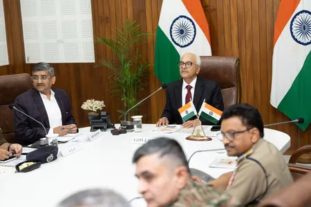 NFRA Chairperson Nitin Gupta presiding over a meeting with officials, seated at a white conference table with Indian flags and microphones.