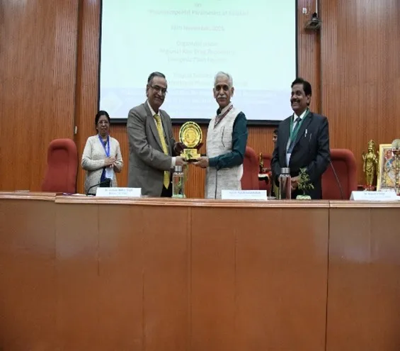 Dr. Raman Mohan Singh presenting a memento to Prof. (Dr.) Mahesh Kumar Dadhich on stage during the PCIM&H awareness programme on pharmacopoeial parameters.