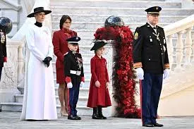 Prince Albert II and Prince Jacques salute while Princess Charlene and Princess Gabriella stand on the steps of the Prince's Palace during Monaco National Day celebrations.