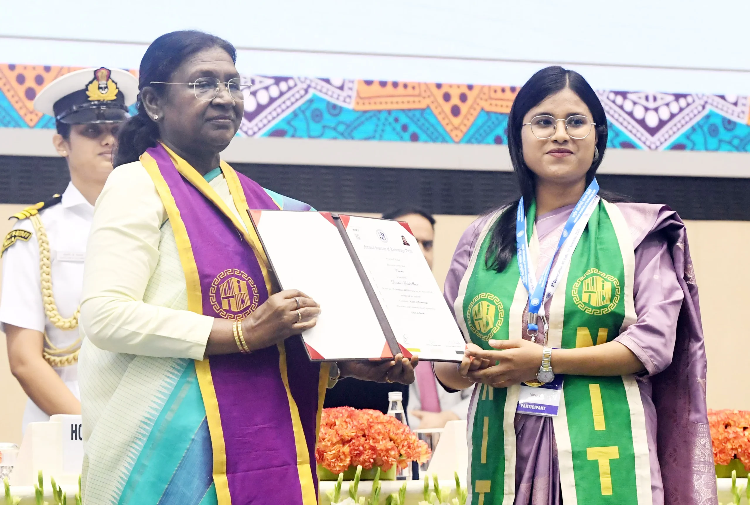 President Droupadi Murmu presents a certificate to a female graduate wearing a green sash during the 5th Convocation ceremony of NIT Delhi.