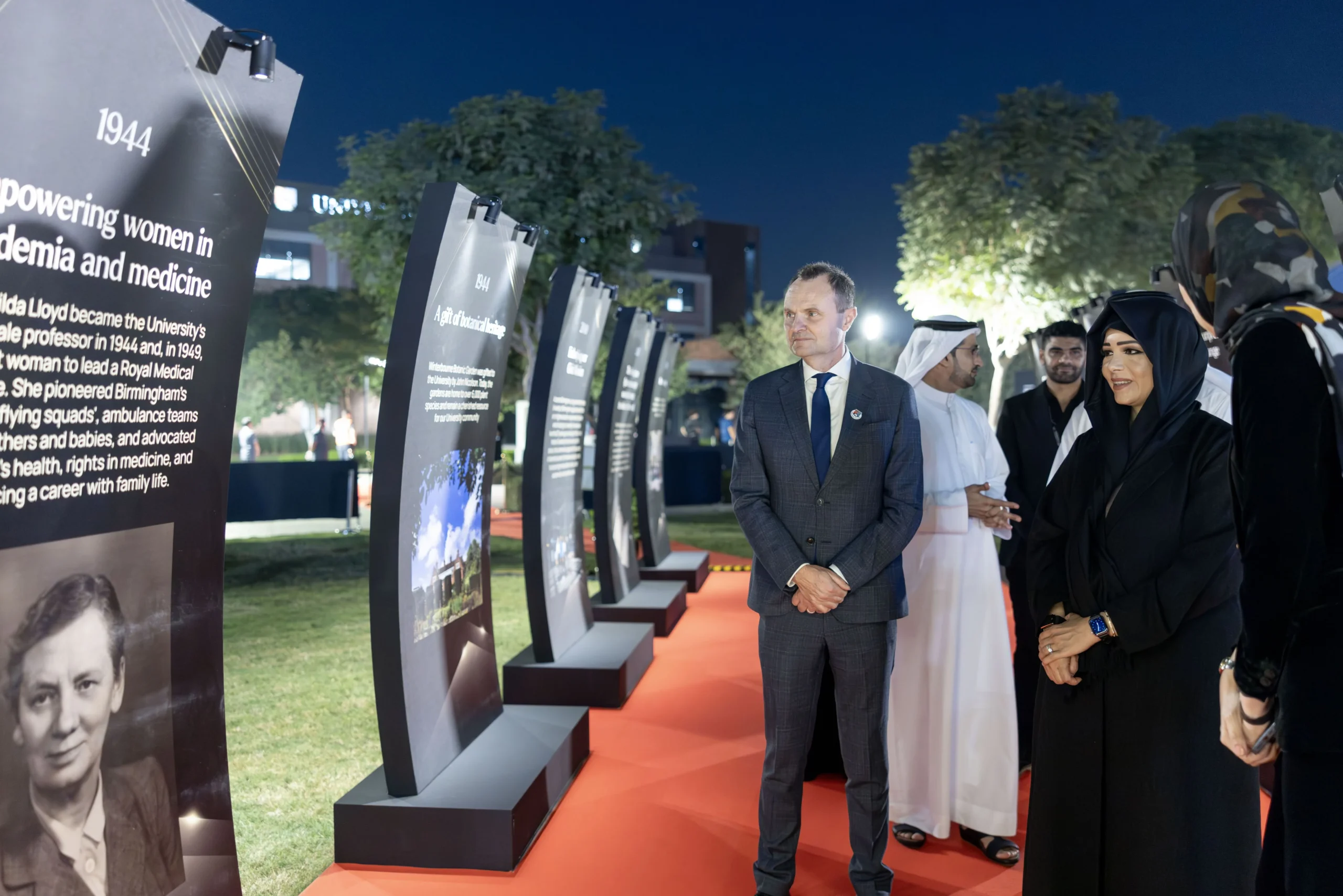 Sheikha Latifa bint Mohammed views historical exhibition panels detailing academic milestones alongside Professor Adam Tickell during the University of Birmingham's 125th anniversary celebration in Dubai.