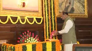 Lok Sabha Speaker Om Birla stands in the Central Hall of Samvidhan Sadan offering floral tributes to a portrait of former Prime Minister Indira Gandhi.