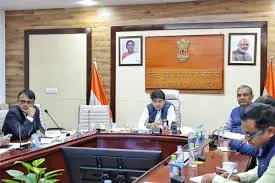 Union Minister Jyotiraditya Scindia chairing a High-Level Task Force meeting at a conference table, flanked by officials and Indian flags, with portraits of President Murmu and PM Modi in the background.