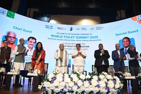 Union Ministers Manohar Lal and C.R. Patil stand on stage with dignitaries during the inaugural ceremony of the World Toilet Summit 2025 in New Delhi, featuring a large digital backdrop and floral arrangements.