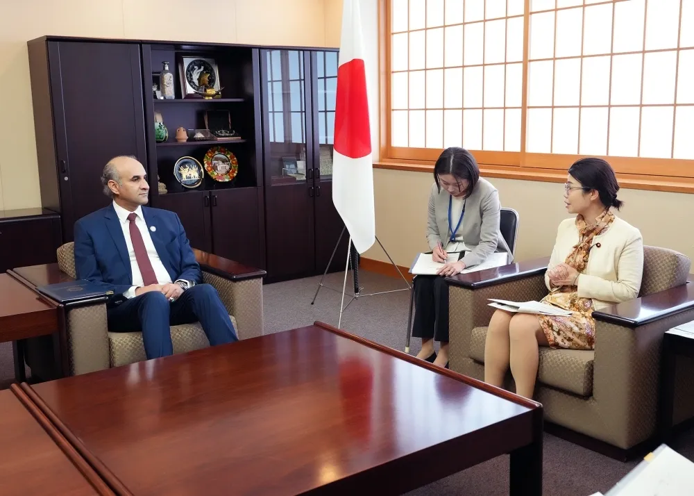 State Minister for Foreign Affairs Kunimitsu Ayano meets with Libyan Chargé d'Affaires Ahmed S. A. Alnaas in a formal reception room with the Japanese flag in the background.