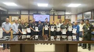 Officials and uniformed personnel holding project documents during the 102nd National Planning Group meeting regarding PM GatiShakti infrastructure projects.