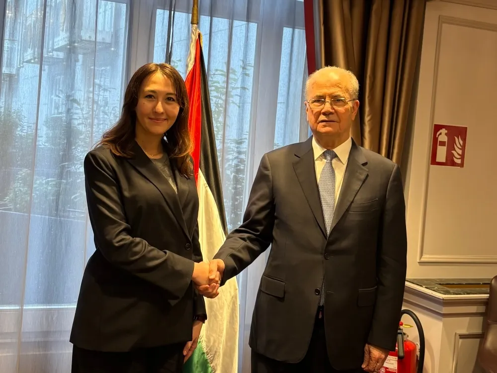 Japanese Parliamentary Vice-Minister Eri Arfiya shakes hands with Palestinian Prime Minister Mohammad Mustafa during a diplomatic meeting in Brussels.