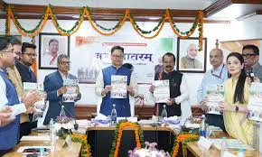 Ministry of Minority Affairs officials standing behind a conference table holding booklets, with garlanded portraits of President Droupadi Murmu and PM Narendra Modi on the wall behind them.