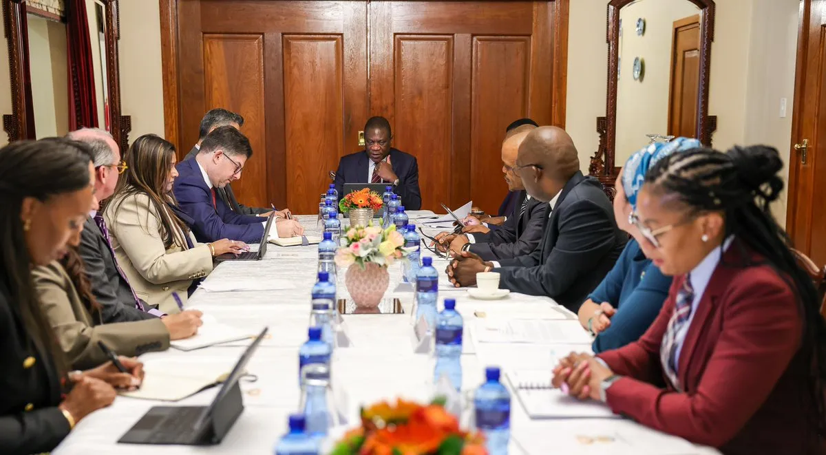 South African Deputy President Paul Mashatile sits at the head of a conference table during a formal meeting with Visa executives and delegation members at OR Tambo House.
