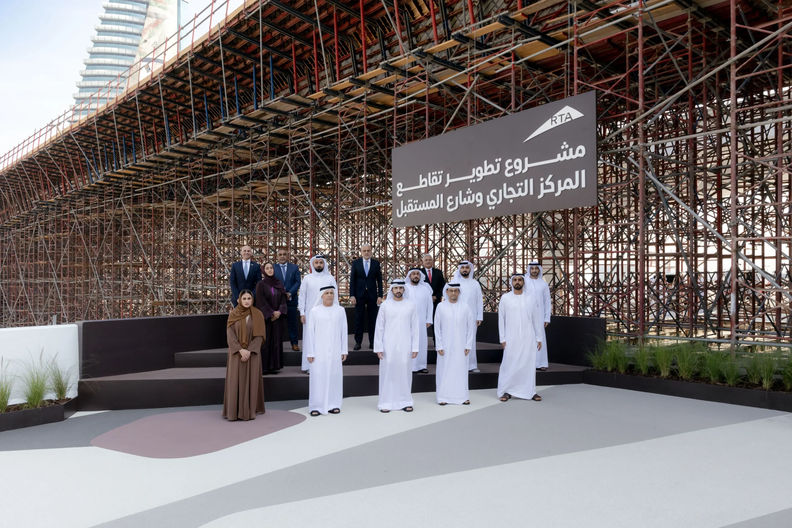 Sheikh Hamdan bin Mohammed standing with Mattar Al Tayer and officials in front of the massive scaffolding infrastructure at the Trade Centre Roundabout construction site in Dubai.