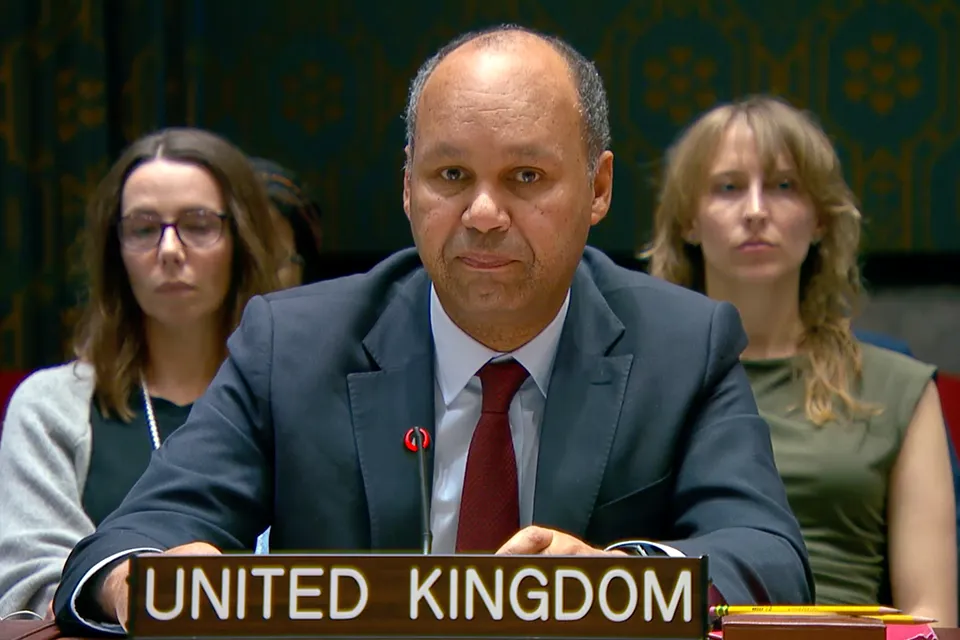 UK Ambassador James Kariuki sits behind the United Kingdom nameplate and microphone during a UN Security Council meeting.
