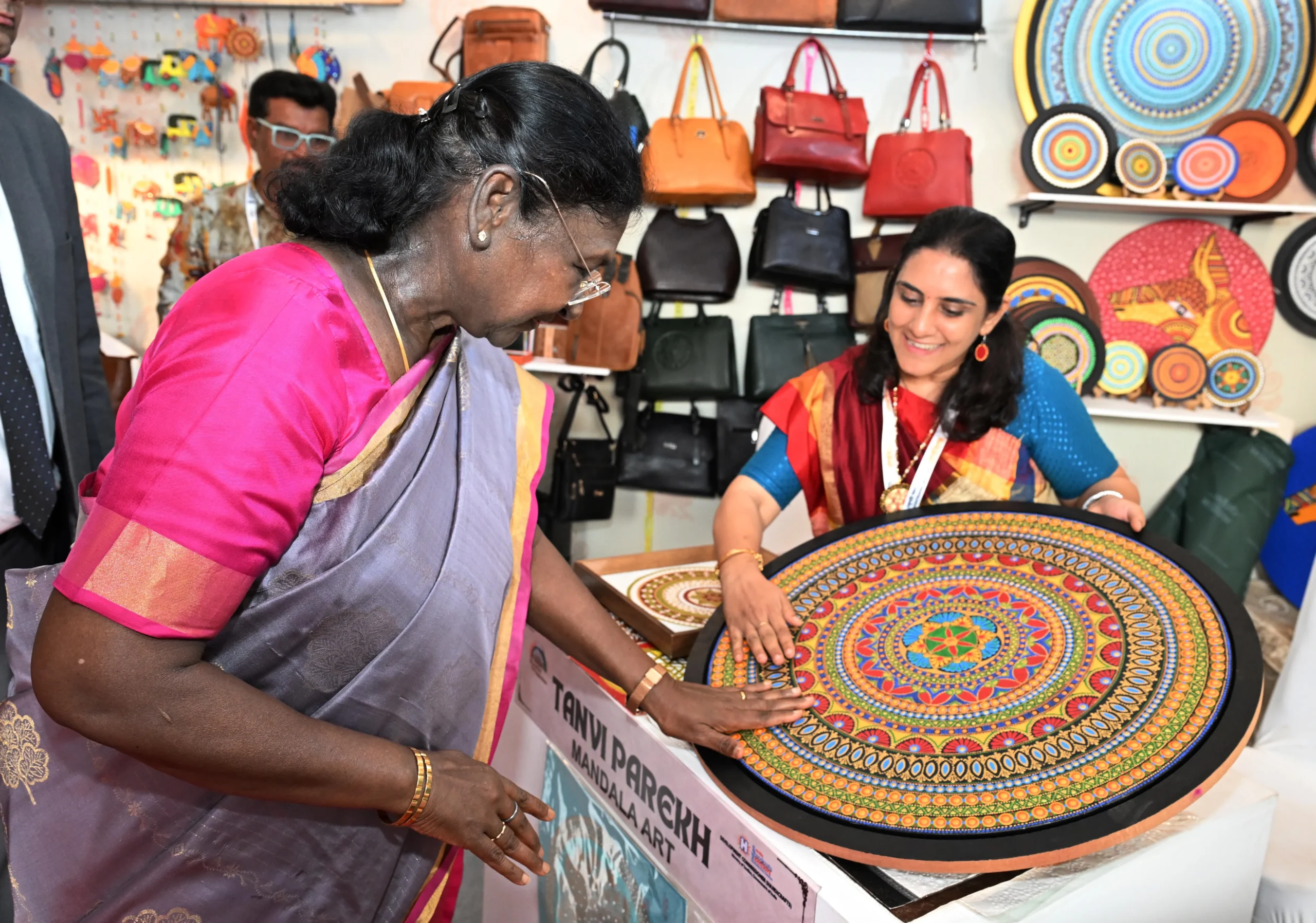 President Droupadi Murmu touches a detailed colorful mandala artwork presented by artist Tanvi Parekh at a stall during the inauguration of the Bharatiya Kala Mahotsav in Secunderabad.