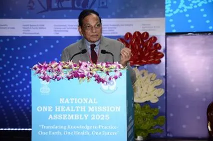 Dr. V.K. Paul, Member (Health), NITI Aayog, addressing the audience at the National One Health Mission Assembly 2025 podium, featuring the slogan 'One Earth, One Health, One Future' and floral decorations.