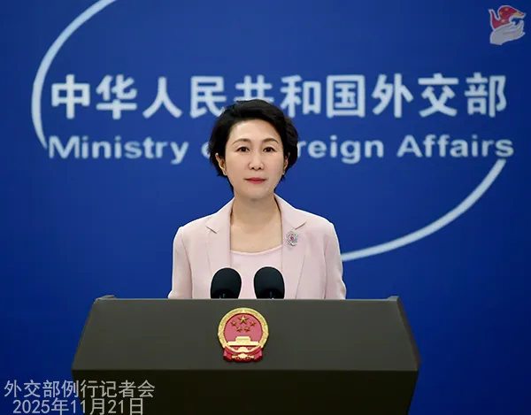 Chinese Foreign Ministry Spokesperson Mao Ning wearing a pink blazer stands at a podium with the national emblem against a blue background during a press conference dated November 22, 2025