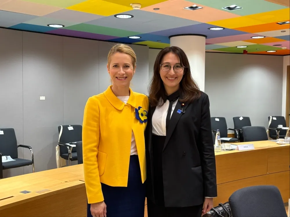 EU High Representative Kaja Kallas wearing a yellow jacket and Japanese Parliamentary Vice-Minister Arfiya Eri in a black suit stand side-by-side at the 4th EU Indo-Pacific Ministerial Forum.