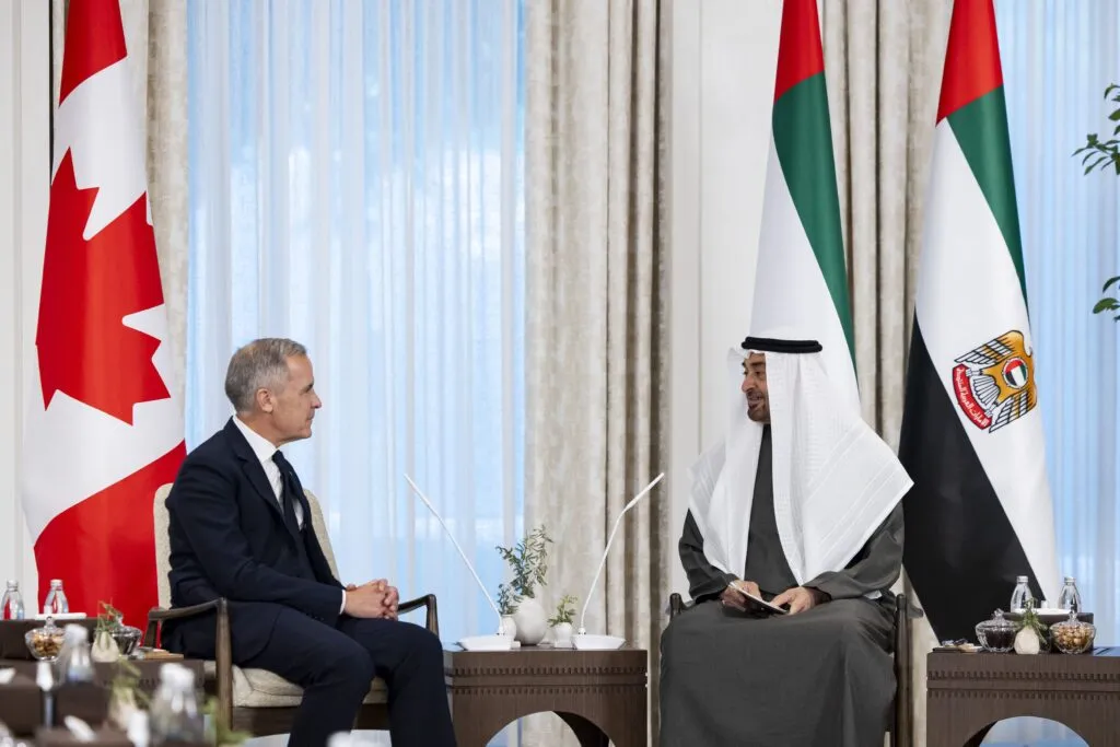 Canada Prime Minister Mark Carney and UAE President Sheikh Mohamed bin Zayed Al Nahyan seated during a diplomatic meeting in Abu Dhabi with national flags in the background.