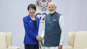 Prime Minister Narendra Modi shakes hands with Japanese Prime Minister Sanae Takaichi in front of a G20 South Africa backdrop in Johannesburg.