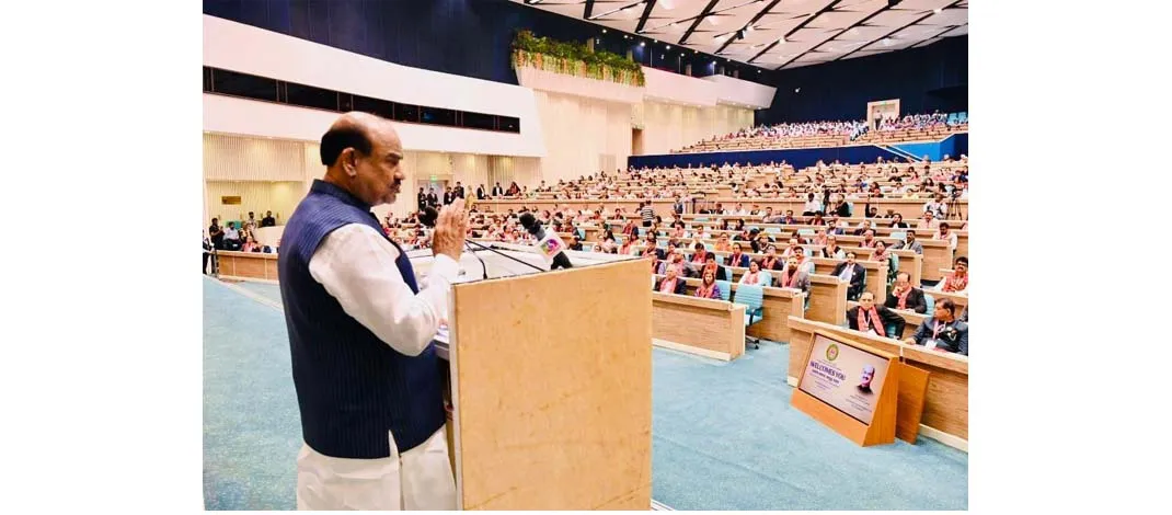 Lok Sabha Speaker Om Birla delivering a speech from a podium at a crowded auditorium during the Sashakt Samaj – Samridh Bharat programme organized by the Vishwa Sindhi Hindu Foundation.