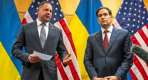 Head of the Ukrainian Presidential Office Andriy Yermak and US Secretary of State Marco Rubio standing at a press conference with Ukrainian and American flags in the background.
