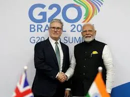 UK Prime Minister Keir Starmer shakes hands with Indian Prime Minister Narendra Modi in front of a G20 Brazil backdrop with their respective national flags in the foreground.