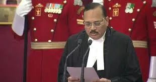 Justice Surya Kant reading the oath of office as Chief Justice of India, wearing judicial robes with the President's Bodyguards standing in the background.