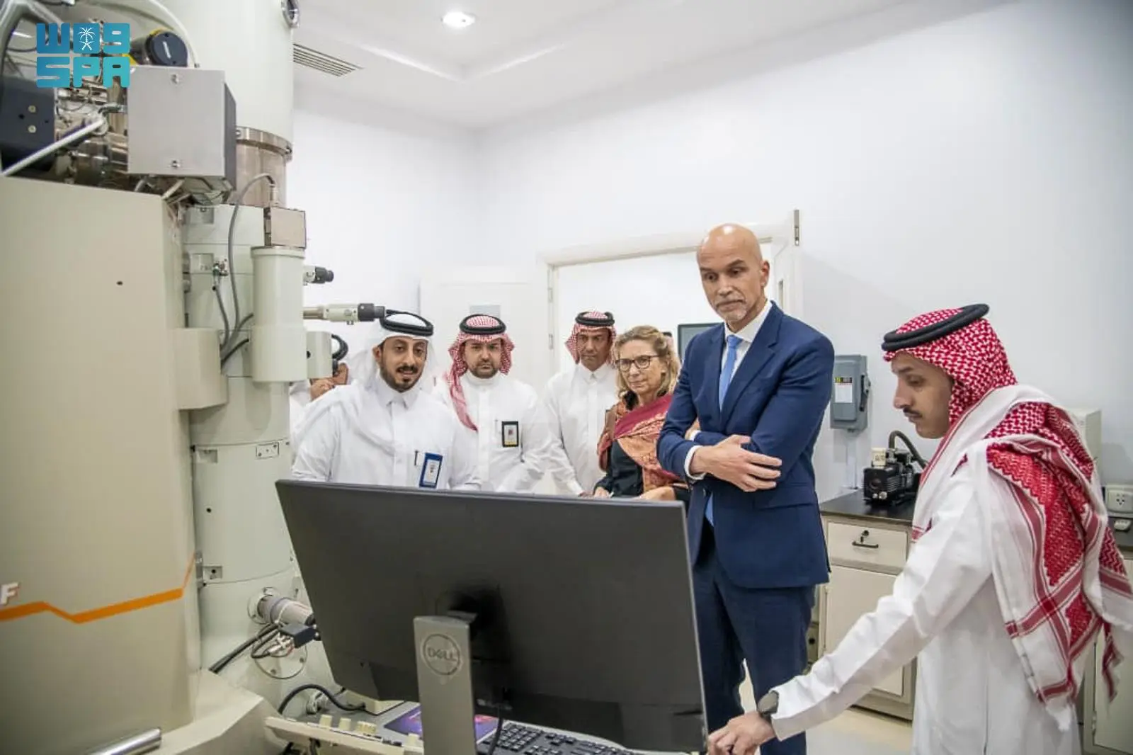 French Consul General Mohammed Nehad and Najran University President Dr. Abdulrahman Al-Khudairi viewing a computer monitor next to a large electron microscope during a laboratory tour.