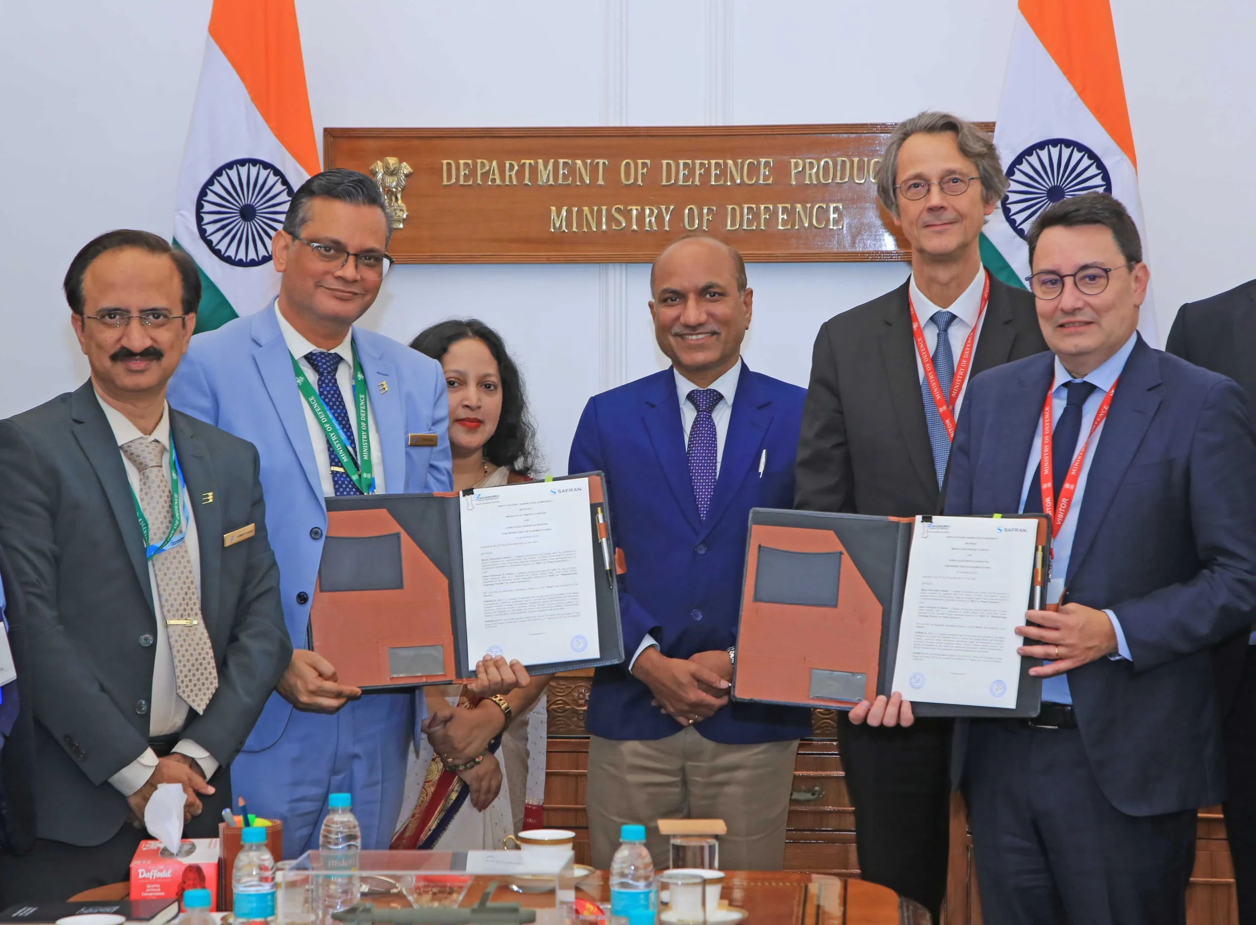 BEL CMD Manoj Jain and Safran EVP Alexandre Ziegler holding signed JVCA documents for HAMMER weapon production in New Delhi with officials.