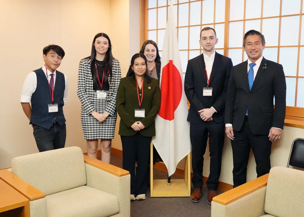 Parliamentary Vice-Minister for Foreign Affairs Yohei Onishi poses with a delegation of Canadian young leaders from the Kakehashi Project in front of the Japanese flag during their courtesy call in Tokyo, November 2025.