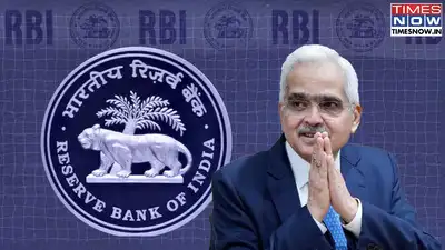 Reserve Bank of India Governor Shaktikanta Das stands with hands in namaste gesture in front of the RBI logo and seal.