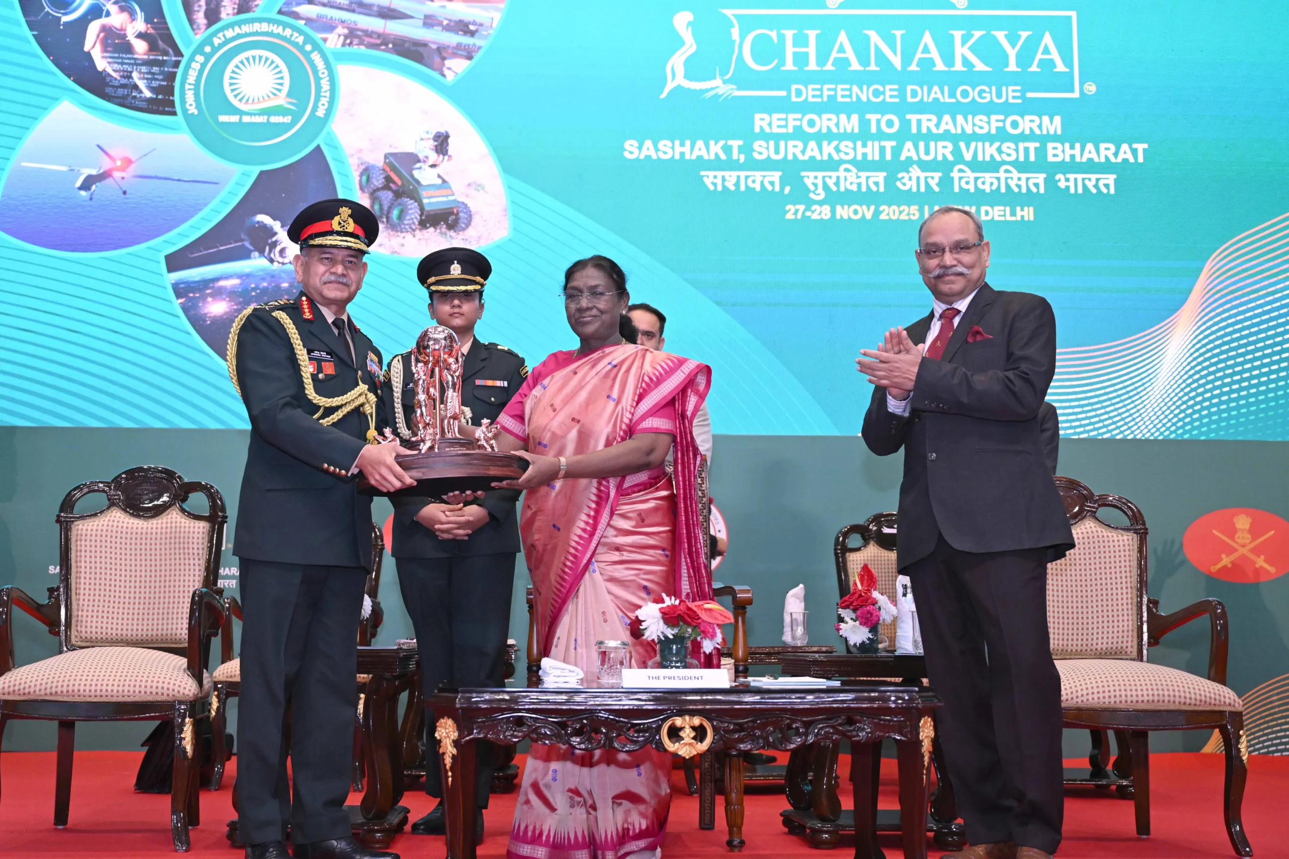 President Droupadi Murmu presents the Chanakya Trophy to a young Indian Army officer during the inaugural session of Chanakya Defence Dialogue-2025 at Manekshaw Centre, New Delhi on 27 November 2025, flanked by Chief of Army Staff General Upendra Dwivedi.
