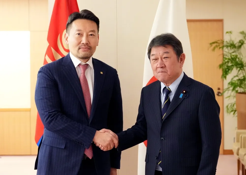Japanese Foreign Minister Toshimitsu Motegi shakes hands with Mongolian Deputy Prime Minister Khassuuri Gankhuyag in front of the Japanese and Mongolian national flags during their bilateral meeting in Tokyo on November 28.